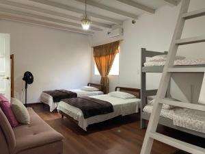 a room with three beds and a ladder at Casa Carito in Cali