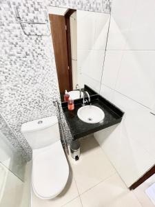 a bathroom with a white toilet and a sink at Studio Cafe duas camas de solteiro in Arapiraca +17 photos