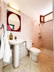 a bathroom with a toilet and a sink and a mirror at Dar Baba Hassan - Ocean View & Ensuite in Taghazout
