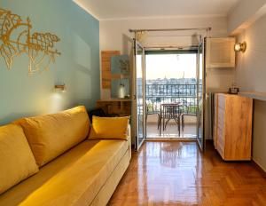 a living room with a couch and a balcony at Zeas Yacht View in Piraeus