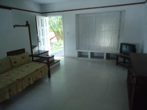 sala de estar con sofá y TV en Complejo Punta Villa en Villa Gesell