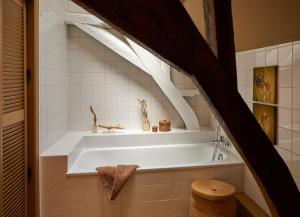 a bathroom with a white tub in a room at Le Nid Fleuri - Séjour familial à Tournai in Tournai
