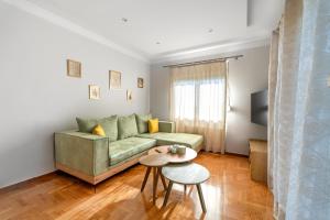 a living room with a green couch and a table at Zeas Yacht View in Piraeus