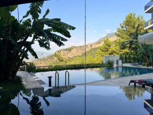 a reflection of a swimming pool in a building at Stylish Lounge Apartment with Pool & Views in Fethiye