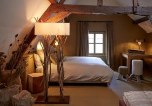 a bedroom with a bed with a lamp and a window at Le Nid Fleuri - Séjour familial à Tournai in Tournai