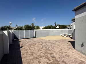 a patio with two benches and a fence at 17 On Sleigh in Langebaan