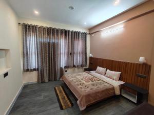 a bedroom with a bed and a large window at Hill Side Heaven Homestay in Nainital