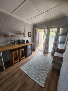 a kitchen and living room with a couch and a table at Cottages on Ilchester in Grahamstown