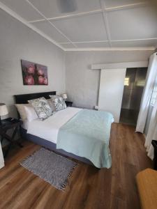 a bedroom with a large bed and a wooden floor at Cottages on Ilchester in Grahamstown