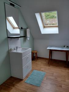 a bathroom with a sink and two skylights at Chambre sous les toits in Baule