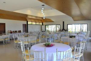 a banquet hall with white tables and chairs at Magalong Beach Resort in Busuanga