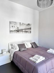 a bedroom with a purple bed with a painting on the wall at The Superhost - Duomo Apt in Crotone