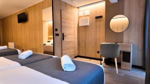 a hotel room with two beds and a chair at Hotel Catanies in Pas de la Casa