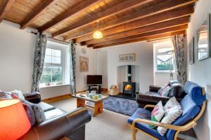 a living room with leather furniture and a fireplace at 3 Bed in Gower oc-hh150 in Llangennith