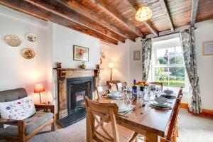 a dining room with a table and a fireplace at 3 Bed in Gower oc-hh150 in Llangennith