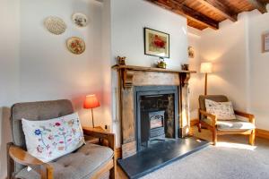 a living room with a fireplace and a chair at 3 Bed in Gower oc-hh150 in Llangennith