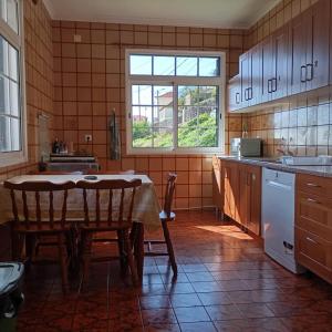 a kitchen with a table and two chairs in it at Yellow Owl II Bedroom II in Campanário