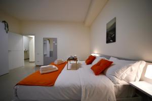 a bedroom with a large white bed with orange pillows at Ètoile Palace Gravina in Gravina in Puglia