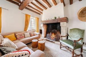 a living room with a couch and a fireplace at Kasa Des Bois in Saint-Arnoult-des-Bois