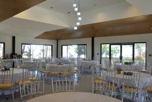 a banquet hall with white tables and chairs at Magalong Beach Resort in Busuanga