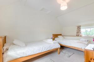 two beds in a room with white walls and a window at 2 Bed in Yatton oc-s32603 in Leinthall Earls