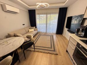 a living room with a couch and a table at Stylish Lounge Apartment with Pool & Views in Fethiye