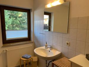 a bathroom with a sink and a mirror and a window at Gästehaus Hundelbach in Lenzkirch +48 photos