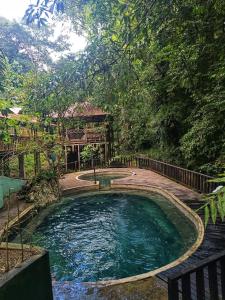 Ein Wasserbecken mit einem Haus im Hintergrund in der Unterkunft Hospedaje Rural Shihumar in Coquí