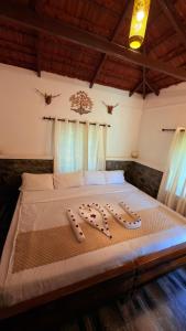 a bed in a room with two slippers on it at Qatsyir Horizon in Varagampadi