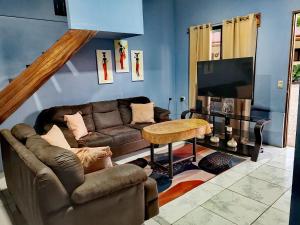 a living room with a couch and a television at Casa Hortensia in Nicoya