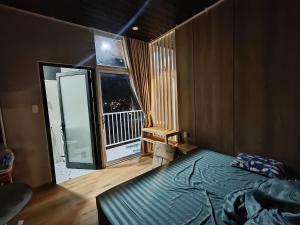 a bedroom with a bed and a large window at Ánh Dương House 2 in Da Thanh