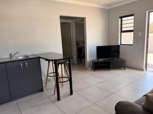 a living room with a table and a kitchen at 17 On Sleigh in Langebaan +11 photos