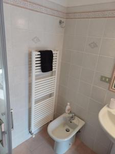 a white bathroom with a sink and a toilet at Corso Ovidio - Casa vacanze in Sulmona +26 photos