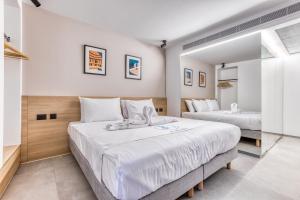 a bedroom with two beds and a mirror at JL Hotel in St. Julianʼs +108 photos