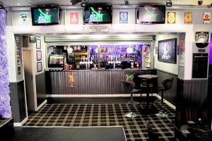 a bar with two stools in front of it at Peek-a-Booze - Budget Hotel - Adults Only in Blackpool