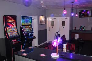 a room with two video game machines and a table at Peek-a-Booze - Budget Hotel - Adults Only in Blackpool