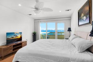 a white bedroom with a large bed and a flat screen tv at Buena Vida 23 in Navarre +63 photos