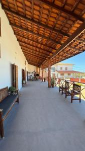 a large patio with benches and a wooden ceiling at Casa Dunas Baleia in Itapipoca