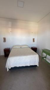a bedroom with a bed and a green table at Casa Dunas Baleia in Itapipoca