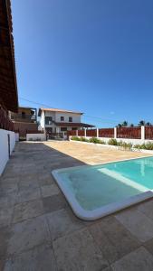 a swimming pool sitting on the side of a house at Casa Dunas Baleia in Itapipoca