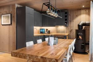 a kitchen with a wooden table and a fireplace at TT28- Ski-in out apartment in Trysil turistcenter with sauna in Trysil