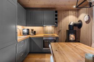 a kitchen with gray cabinets and a wooden table at TT28- Ski-in out apartment in Trysil turistcenter with sauna in Trysil