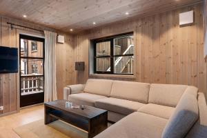 a living room with a couch and a coffee table at TT28- Ski-in out apartment in Trysil turistcenter with sauna in Trysil +17 photos