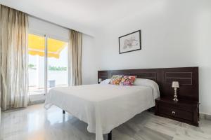 een slaapkamer met een groot bed en een groot raam bij Puerto Banus Luxury Penthouse in Marbella +27 foto's