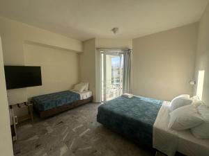 ein Hotelzimmer mit zwei Betten und einem Fernseher in der Unterkunft Rodon Hotel in Chania + 64 Fotos