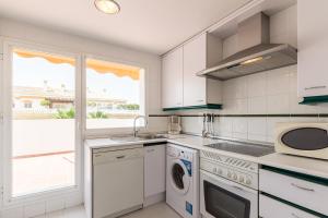 een witte keuken met een wastafel en een magnetron bij Puerto Banus Luxury Penthouse in Marbella