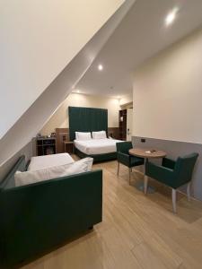 a room with two beds and a table and chairs at JR Hotels Bocconi Milano in Milan +38 photos