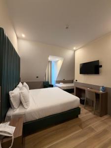 a hotel room with a bed and a television at JR Hotels Bocconi Milano in Milan