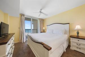 a bedroom with a large bed and a television at Pelican Beach 1216 - Ocean Front Condo with Shared Pool & Beach Access in Destin +30 photos