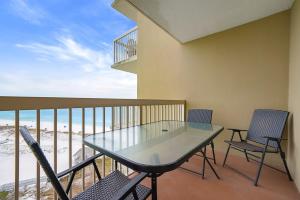 a balcony with a table and chairs and the beach at Pelican Beach 1216 - Ocean Front Condo with Shared Pool & Beach Access in Destin